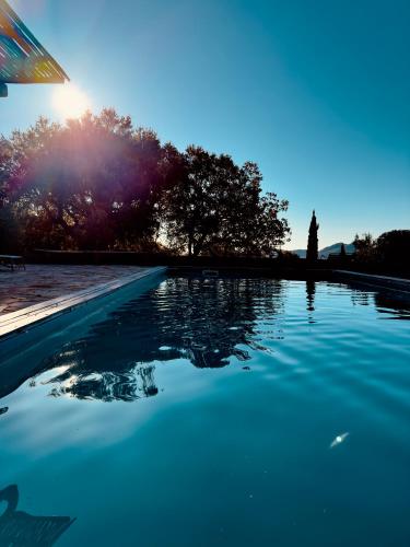 un bassin d'eau bleue avec des arbres en arrière-plan dans l'établissement Villa 6 personnes avec piscine partagée, à Conca