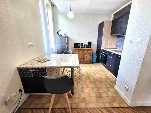 une petite cuisine avec un comptoir et une chaise dans l'établissement Résidence Le Juturna - Studio à proximité du centre ville et des Thermes d'Aix-les-Bains ! MAE-7054, à Aix-les-Bains