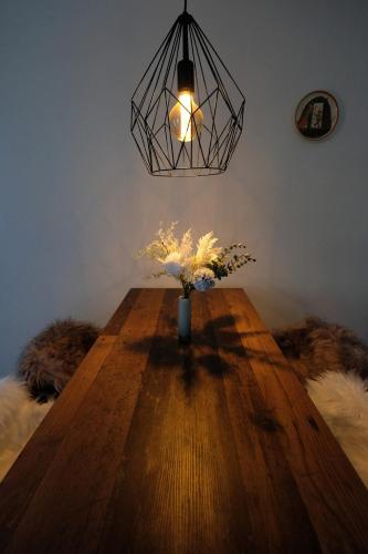 a table with a vase of flowers on top of it at Charming Studio - Ferienwohnung - Vulpera, Scuol in Scuol