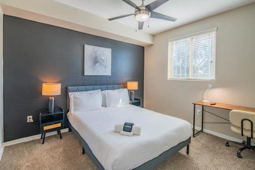 a bedroom with a large bed with a desk and a ceiling fan at Spacious 2BD - ASU - Sloan Pk - WD Parking Sleeps 8 in Tempe
