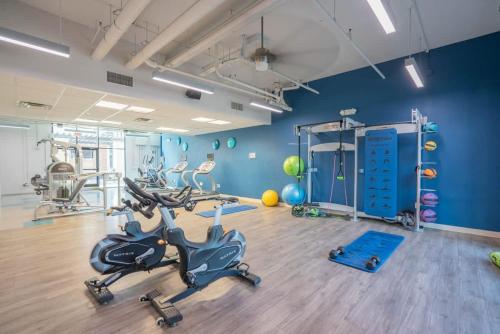 a gym with exercise bikes in a room with blue walls at Spacious 2BD - ASU - Sloan Pk - WD Parking Sleeps 8 in Tempe