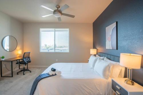 a bedroom with a large white bed with a ceiling fan at Stylish 1BD - Balcony, Pool, Gym, W-D - Sleeps 4 in Tempe