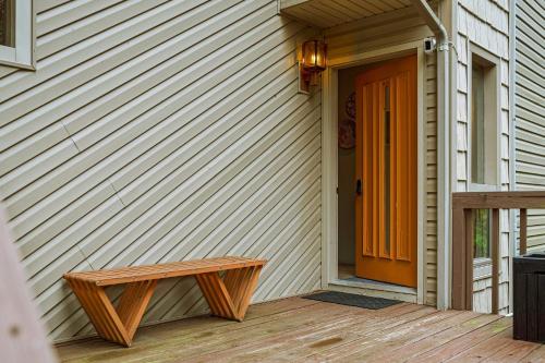 an orange door on the side of a house with a bench at Emerald Bluff by AvantStay Lake Views Deck Fire Pit Game Room in Long Pond