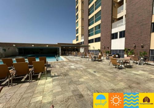 an outdoor patio with tables and chairs on a building at Piazza diRoma com acesso ao Acqua Park - Temporada CN in Caldas Novas
