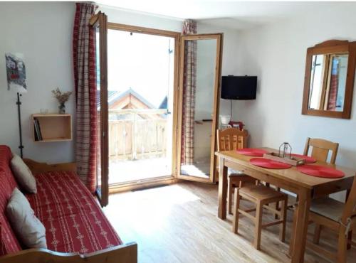 - un salon avec une table à manger et une chambre dans l'établissement Appartement chalet à la montagne, à Albiez-Montrond