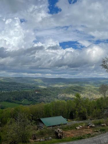 a building with a green roof on top of a hill at Tree Top View of lookout mountain in Rising Fawn