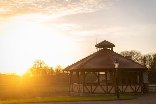 a gazebo in the middle of a field at Folwark Pszczew in Pszczew
