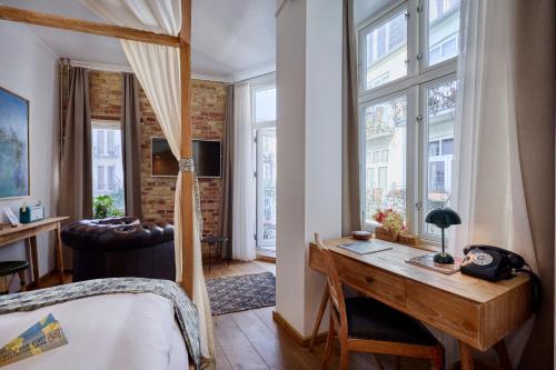 a bedroom with a desk and a large window at Axel Guldsmeden in Copenhagen