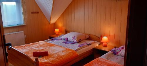 a small bedroom with two beds and two lamps at Agroturystyka Pod Złotą Wiechą in Uście Gorlickie