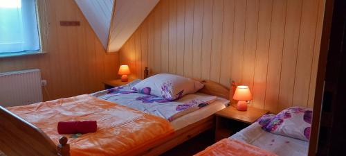 a small bedroom with two beds and two lamps at Agroturystyka Pod Złotą Wiechą in Uście Gorlickie