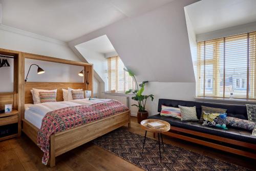 a bedroom with a large bed and a couch at Axel Guldsmeden in Copenhagen