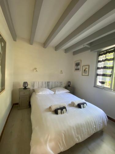 a bedroom with a white bed with two towels on it at Villa Dreamland à Seignosse océan in Seignosse