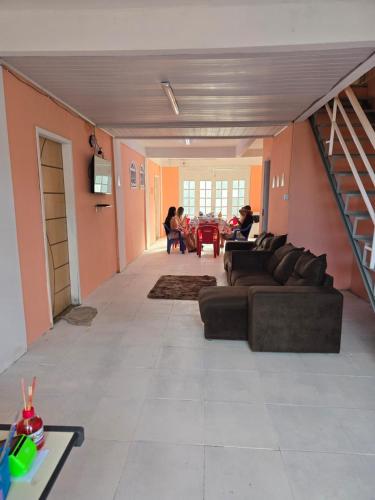 a living room with couches and a table and people at Hostel Sol do Alcaíra in Arraial do Cabo