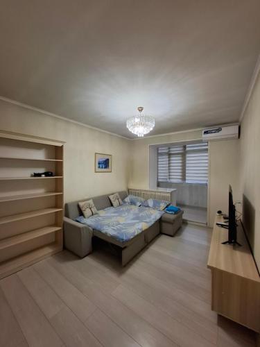 una camera da letto con un letto e una televisione di One-bedroom apartment in the city center a Bishkek