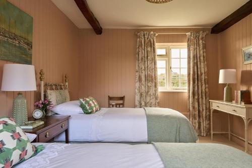 une chambre d'hôtel avec deux lits et une fenêtre dans l'établissement Haybarn Cottage, à Alton