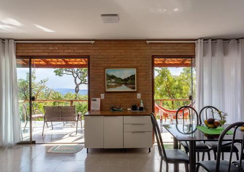 a kitchen and dining room with a table and chairs at Chalé Belvedere Veadeiros in Alto Paraíso de Goiás