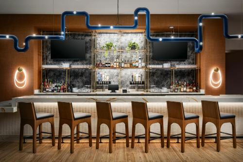a bar with chairs and a table with a bar at The Nobleman Fort Worth, Tapestry Collection By Hilton in Fort Worth