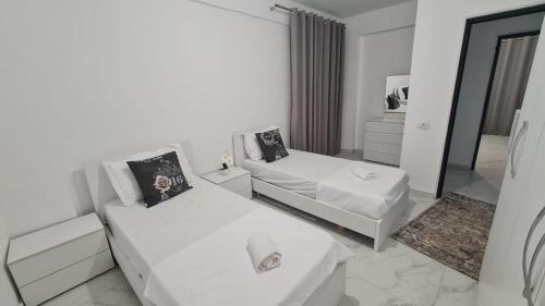 biały pokój z dwoma łóżkami i lustrem w obiekcie Sole Hause w mieście Golem