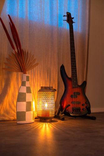 a guitar sitting next to a vase and a lamp at The Creative Boat in Lithoijen
