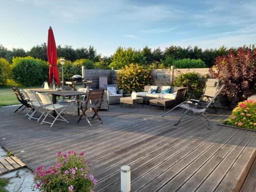 a wooden deck with a table and chairs on it at Gîte L'Orée de Deauville in Saint-Gâtien-des-Bois