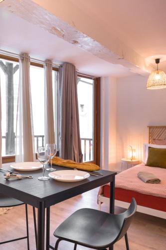 Cette chambre comprend une table avec deux chaises et un lit. dans l'établissement Le Sauvignon, à Bergerac