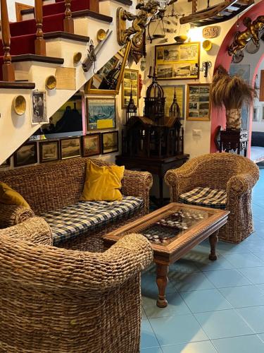 a living room with wicker chairs and a table at Hotel Oriente in Lipari