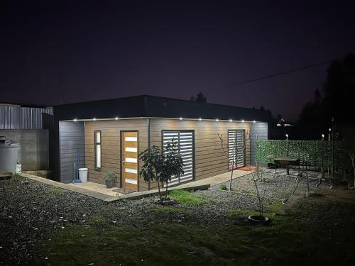 a small house with lights on it at night at Cabaña entre Bosques in Concepción