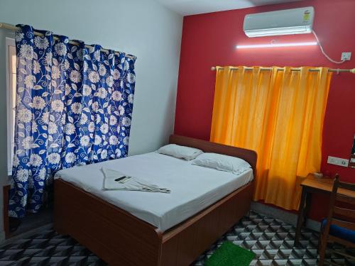 a small bedroom with a bed and a curtain at Sidds Hospitality Inn in kolkata