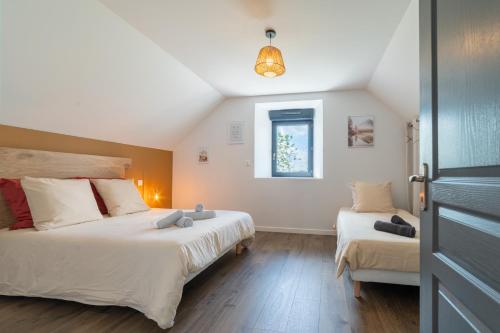 a bedroom with two beds and a window at Les Combettes - Terrasse, Jardin & Proche Lac in Moyrazès