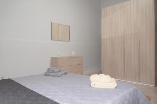 una camera da letto con un letto con asciugamani sopra di Holiday Home Palermo - Centro Storico a Palermo