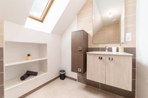 a bathroom with a sink and a cabinet in a attic at Les Combettes - Terrasse, Jardin & Proche Lac in Moyrazès