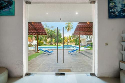 an open door of a house with a swimming pool at Tranquilo - Private Pool Near Beach Sleeps 16 in Ixtapa