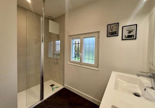 une salle de bain blanche avec une douche et un lavabo dans l'établissement Maison de ville esprit campagne 3 chambres, à Poitiers