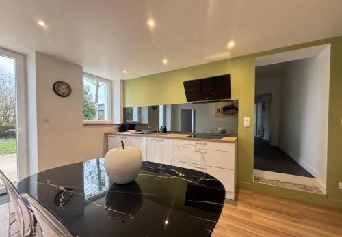 une cuisine avec une table en verre et un comptoir dans l'établissement Maison de ville esprit campagne 3 chambres, à Poitiers