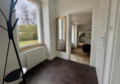 - un couloir avec un miroir et une chaise dans la chambre dans l'établissement Maison de ville esprit campagne 3 chambres, à Poitiers