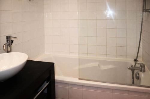 une salle de bain avec un lavabo et une baignoire dans l'établissement Chalet La Combe D Or - Chalet mitoyen en résidence de standing MAE-0854, aux Orres