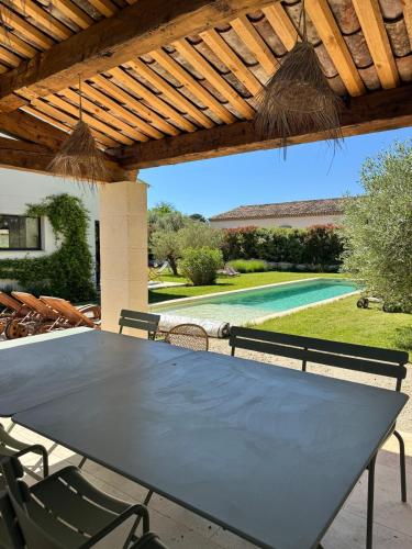 un patio avec une table et des chaises sous une pergola dans l'établissement Family home in Provence, à Aix-en-Provence