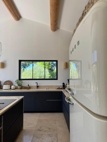 une cuisine avec des armoires noires et une fenêtre dans l'établissement Family home in Provence, à Aix-en-Provence
