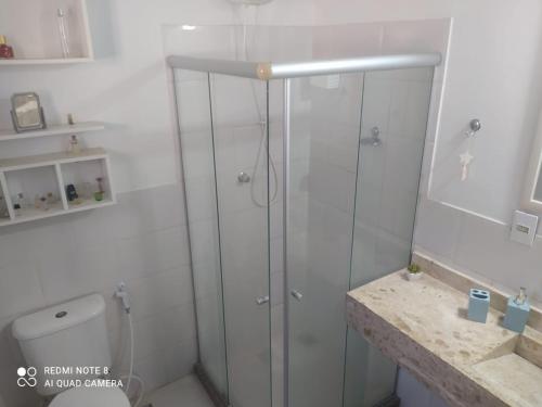 a white bathroom with a shower and a toilet at Casa Praia Rasa in Búzios