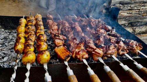 a bunch of meat and skewers on a grill at Tatev& Alex BnB in Tatʼev