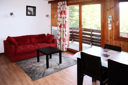 un salon avec un canapé rouge et une table dans l'établissement Residence La Combe D Or - Appartement en résidence de standing MAE-6284, aux Orres