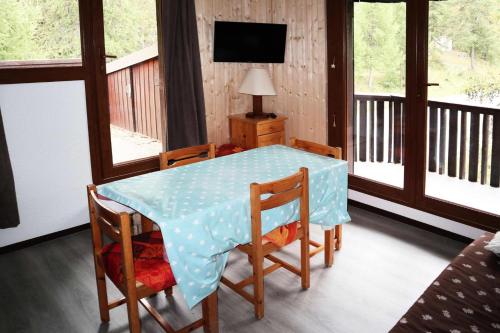 d'une table à manger avec des chaises et d'une télévision sur un balcon. dans l'établissement Résidence Le Pouzenc - Grand studio 4/6 personnes MAE-0814, à Le Mélézet