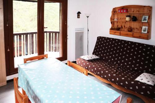 un lit et un canapé dans une chambre avec balcon dans l'établissement Résidence Le Pouzenc - Grand studio 4/6 personnes MAE-0814, à Le Mélézet