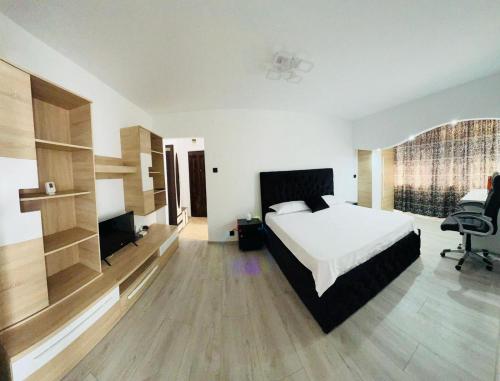 a bedroom with a bed and a desk and a chair at Apartament Tudorache Premium 1 in Turceni