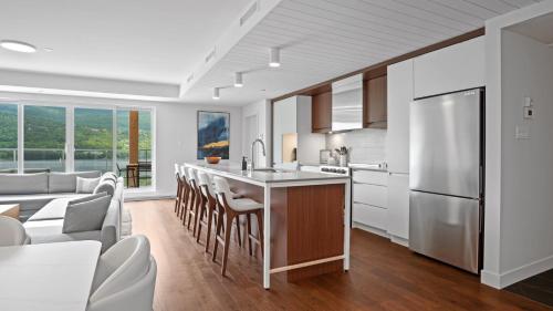a kitchen and living room with a couch and a refrigerator at Lago by Tremblant Platinum in Mont-Tremblant