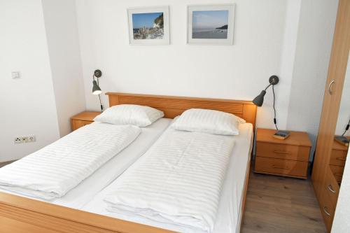 two twin beds in a bedroom with two lamps at schöne Ferienwohnungen im Zentrum von Rügen in Thesenvitz
