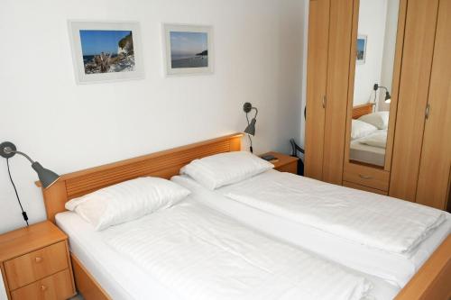 a bedroom with two beds and a mirror at schöne Ferienwohnungen im Zentrum von Rügen in Thesenvitz