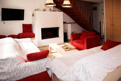 - un salon avec un lit et deux chaises rouges dans l'établissement Chalet La Combe D Or - Superbe chalet 10 personnes MAE-3584, à Le Mélézet