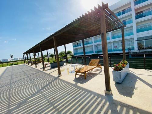 a boardwalk with benches and a building at Cabaña frente al mar in Tubará