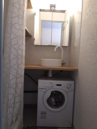 une petite salle de bains avec un lave-linge et un lavabo dans l'établissement Studio Grau du Roi avec piscine, au Grau-du-Roi